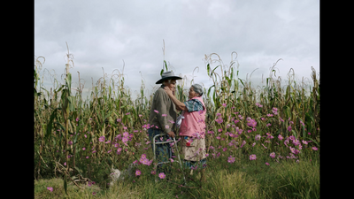 a man and a little girl standing in a field of flowers