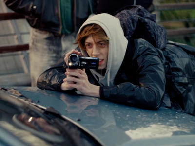 a young man taking a picture of himself on a car