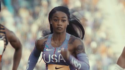 a woman running in a race in a stadium