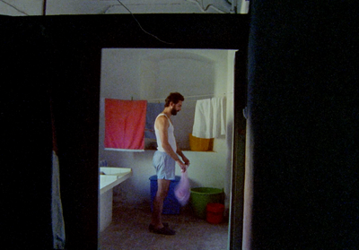 a man standing in a bathroom holding a bag