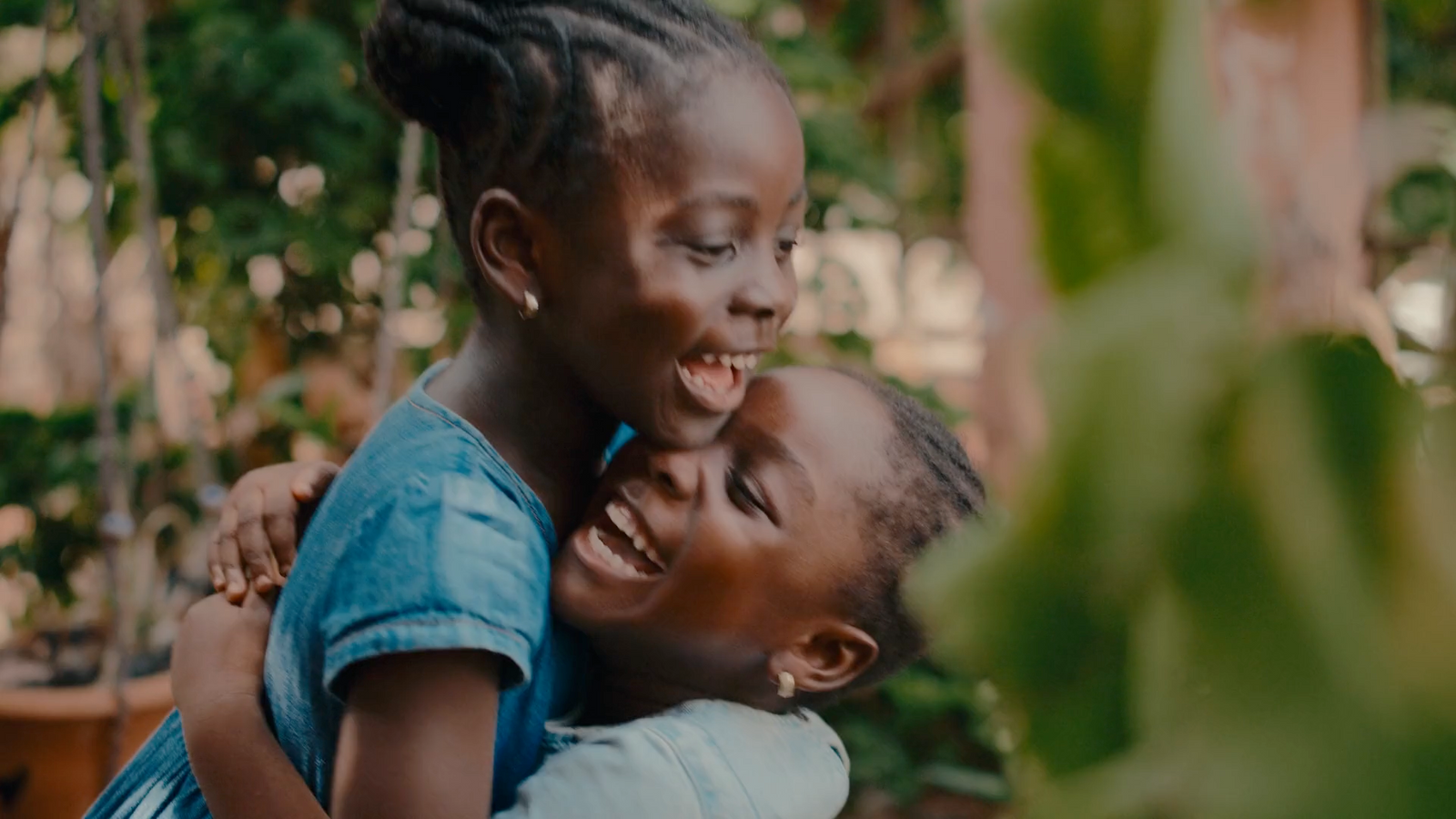 a woman hugging another woman in a garden