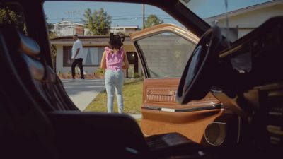 a woman standing next to a car with the door open