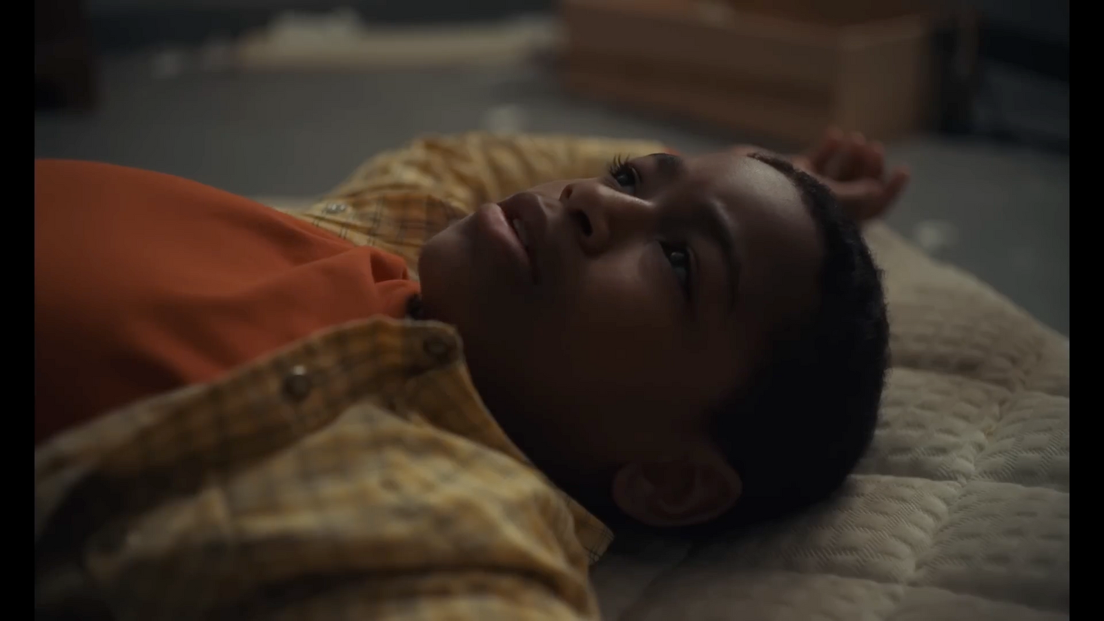 a young boy laying on top of a bed