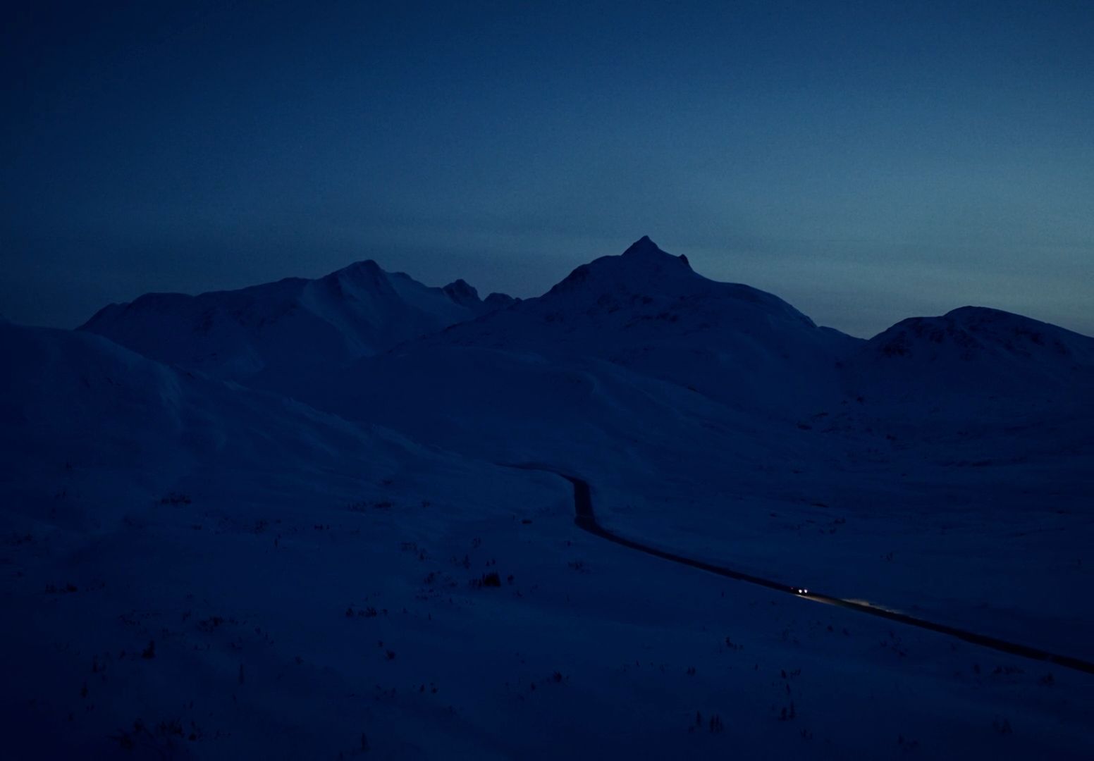 a road in the middle of a snow covered mountain