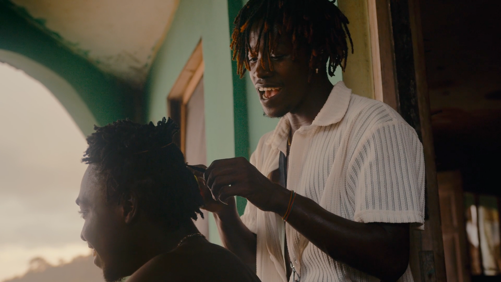 a man getting his hair cut by another man