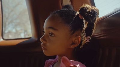 a little girl sitting in the back seat of a car