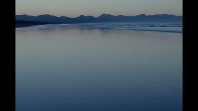 a body of water with mountains in the background