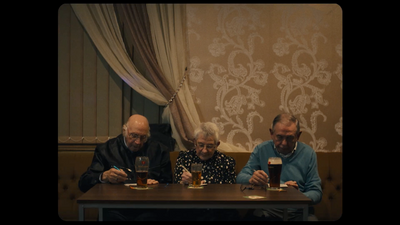 a group of people sitting at a table with beers