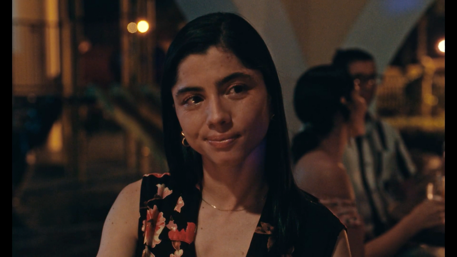 a woman in a floral top is smiling at the camera