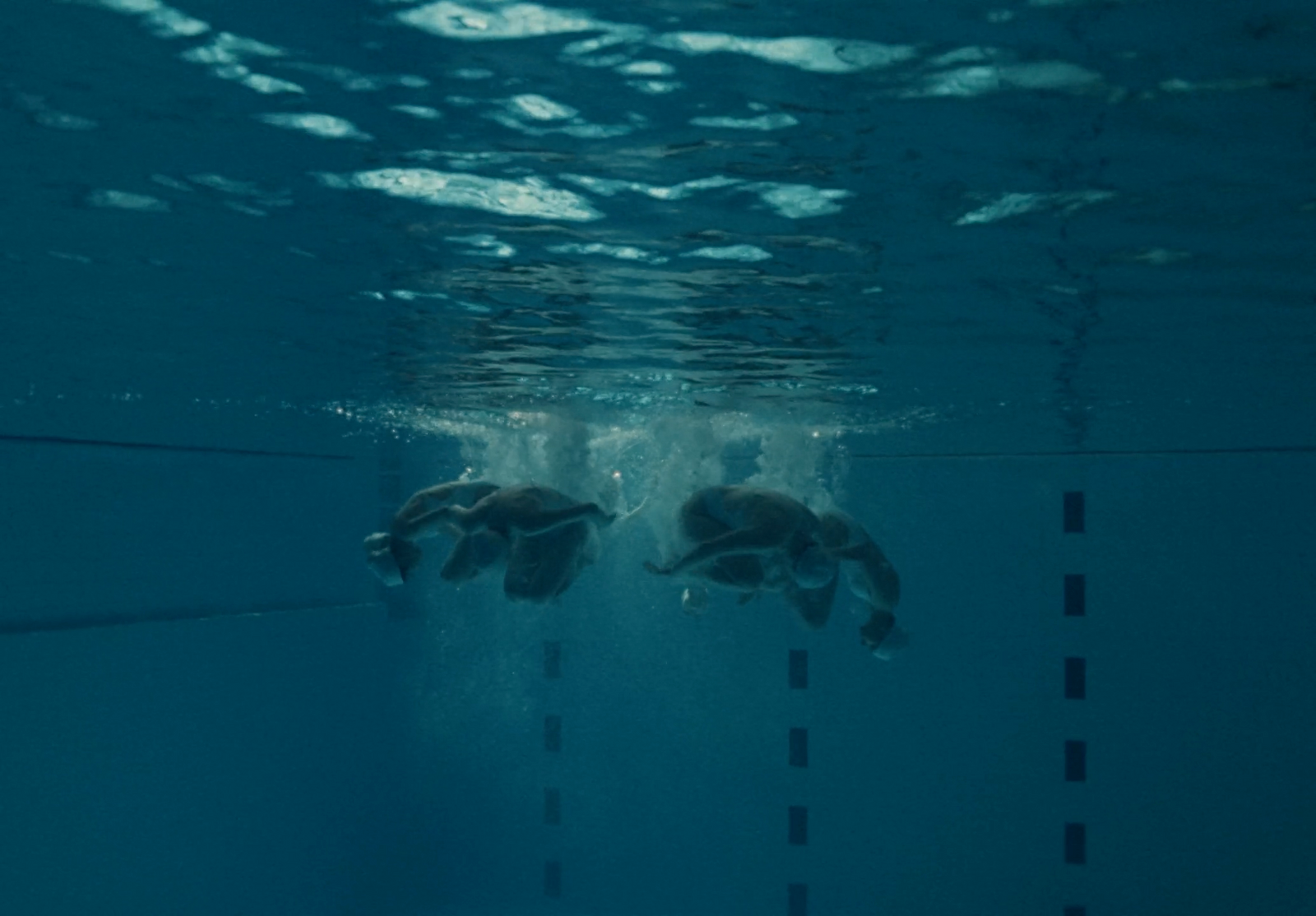 a couple of people swimming in a pool