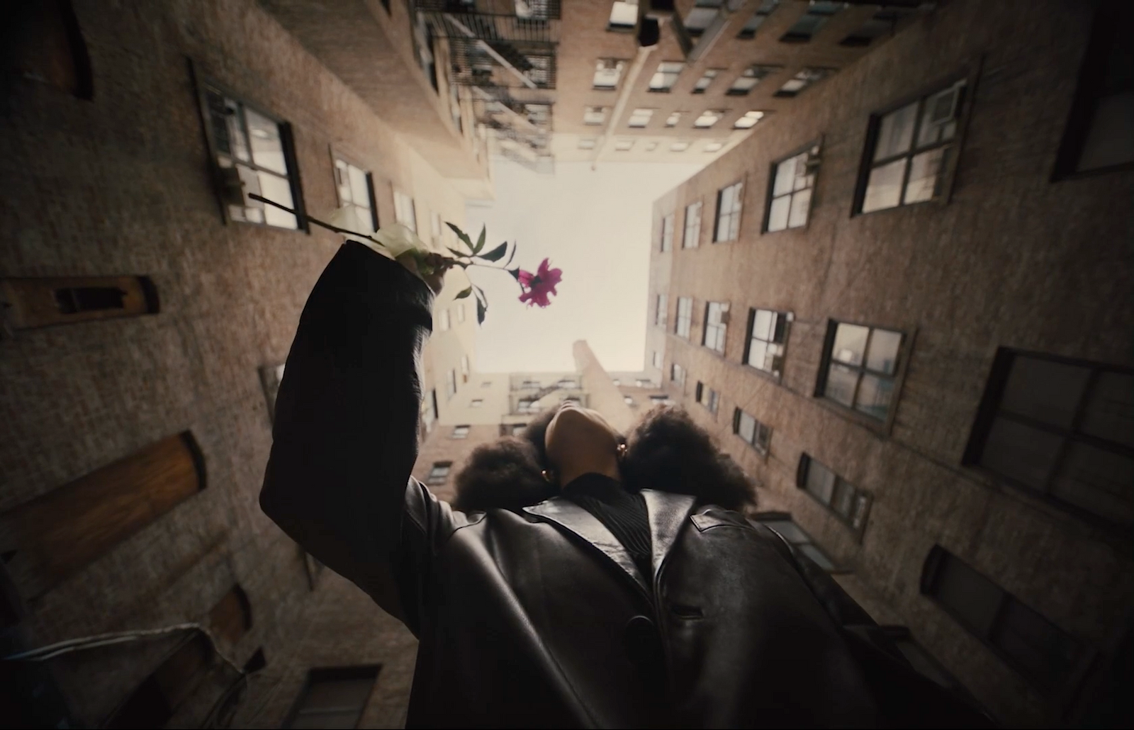 a person holding a flower in the middle of a room