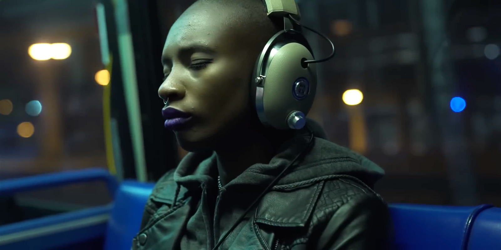 a woman wearing headphones sitting on a bus