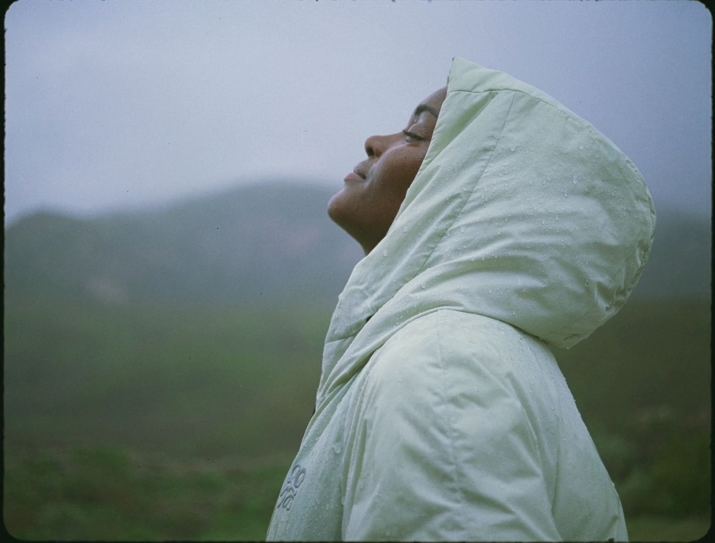 a woman in a white jacket looking up at the sky