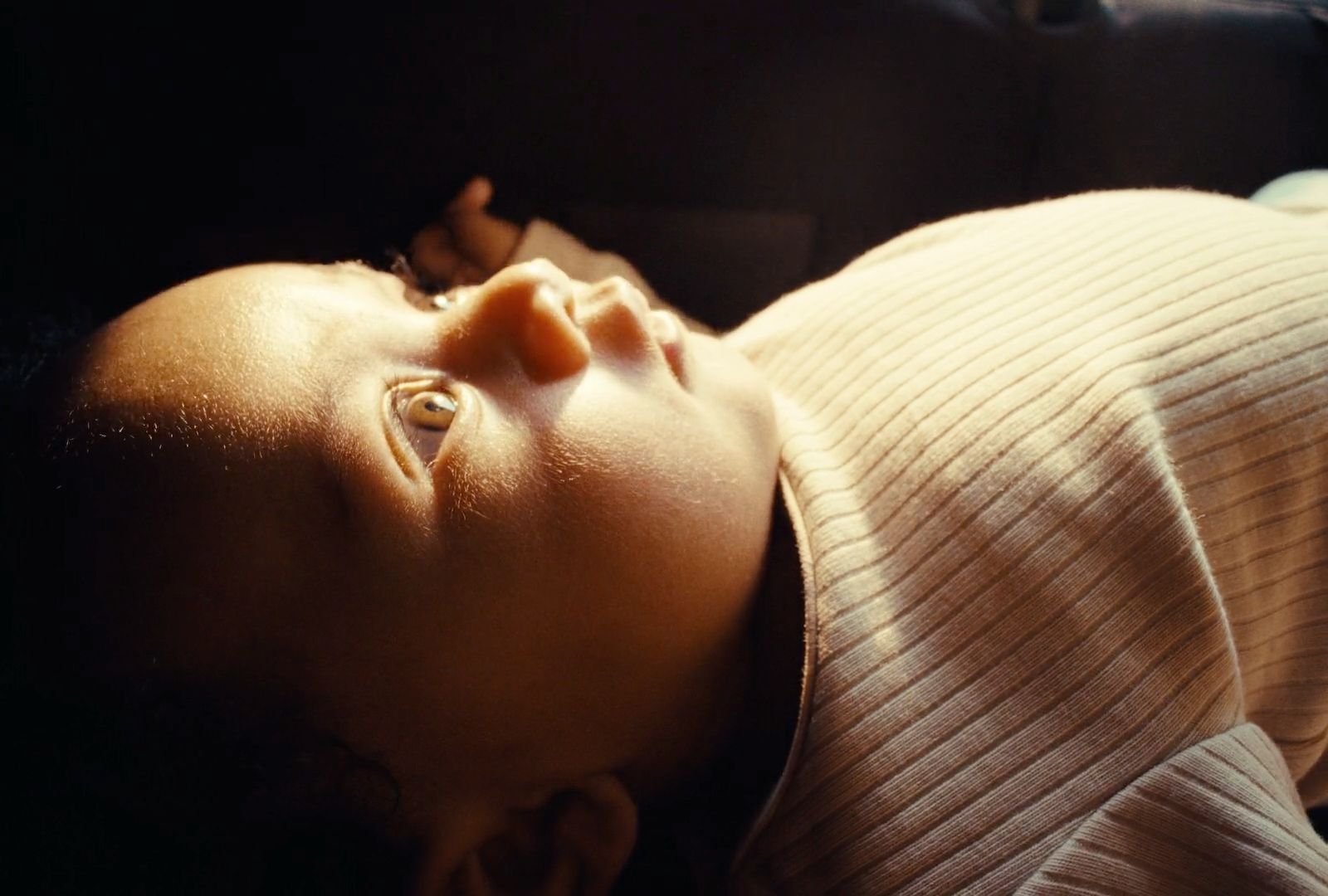 a close up of a baby laying on a bed