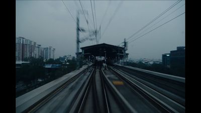 a train traveling down train tracks next to a tall building