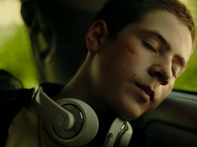 a man sleeping in a car with headphones on