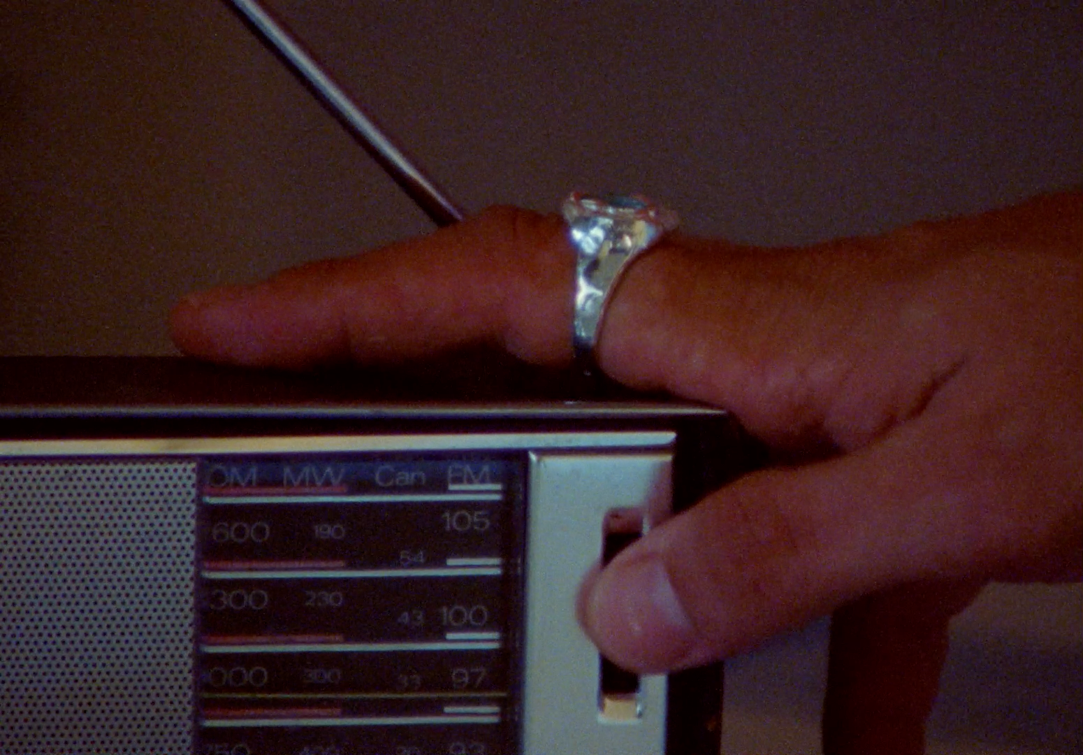 a person holding a ring on top of a radio