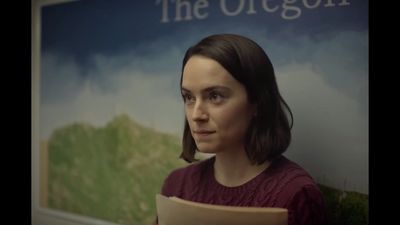 a woman is standing in front of a sign