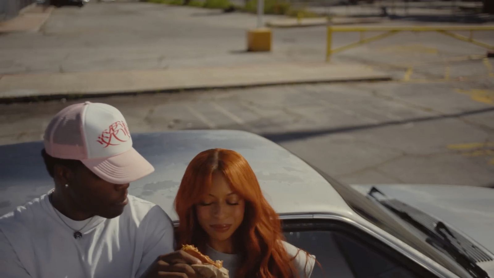 a man and a woman standing next to a car