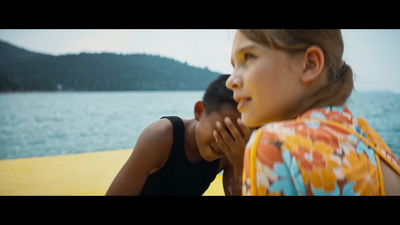 a woman and a child sitting next to each other near a body of water