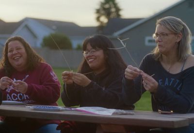 a group of women sitting at a picnic table