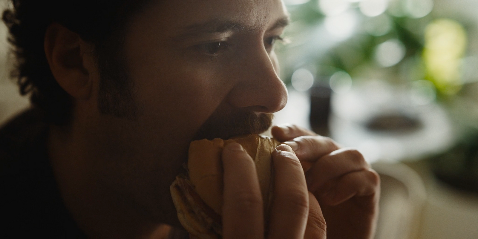 a man is eating a hot dog in a restaurant