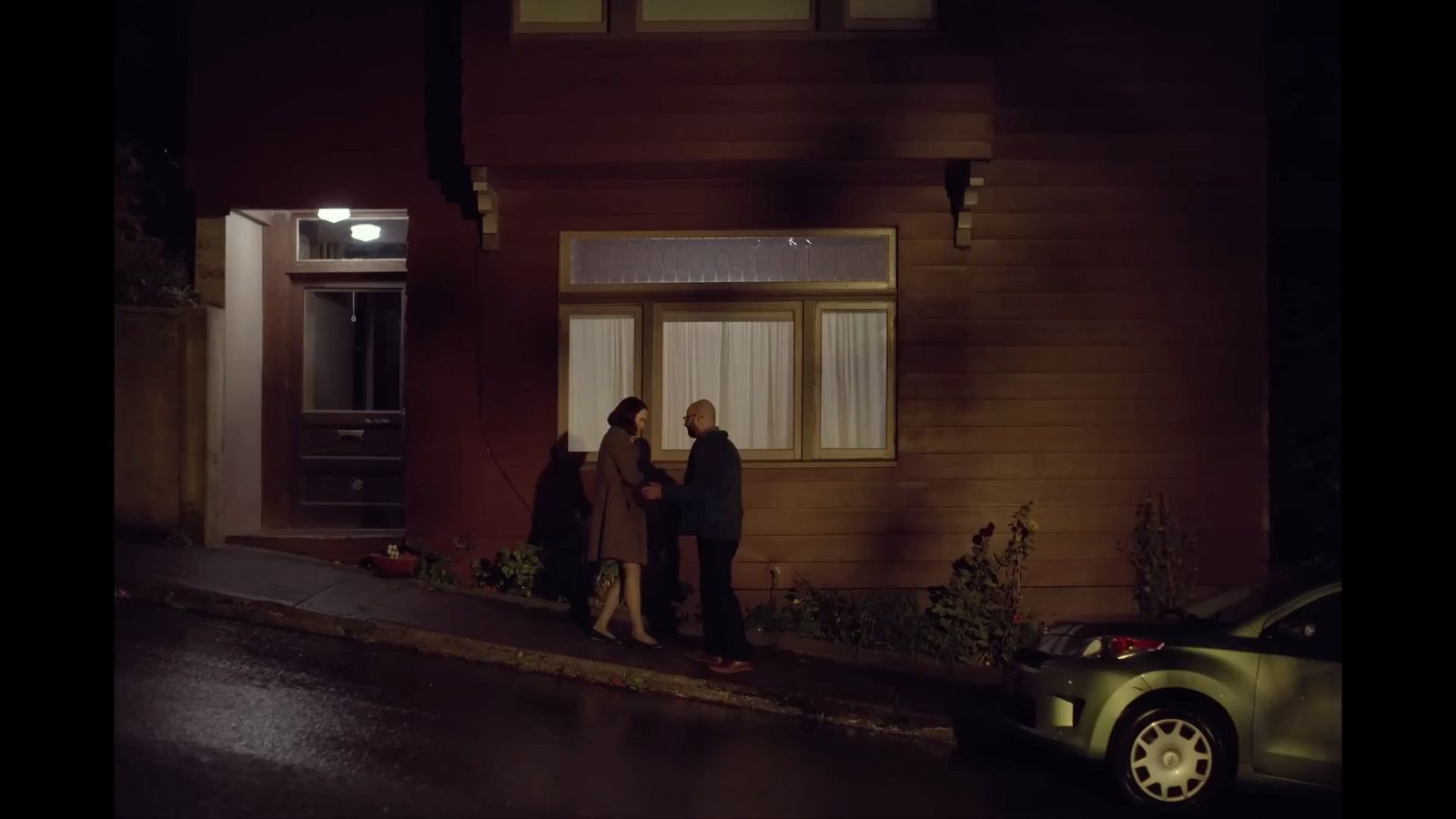 a group of people standing outside of a house at night