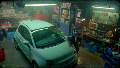 a green car is parked in a garage