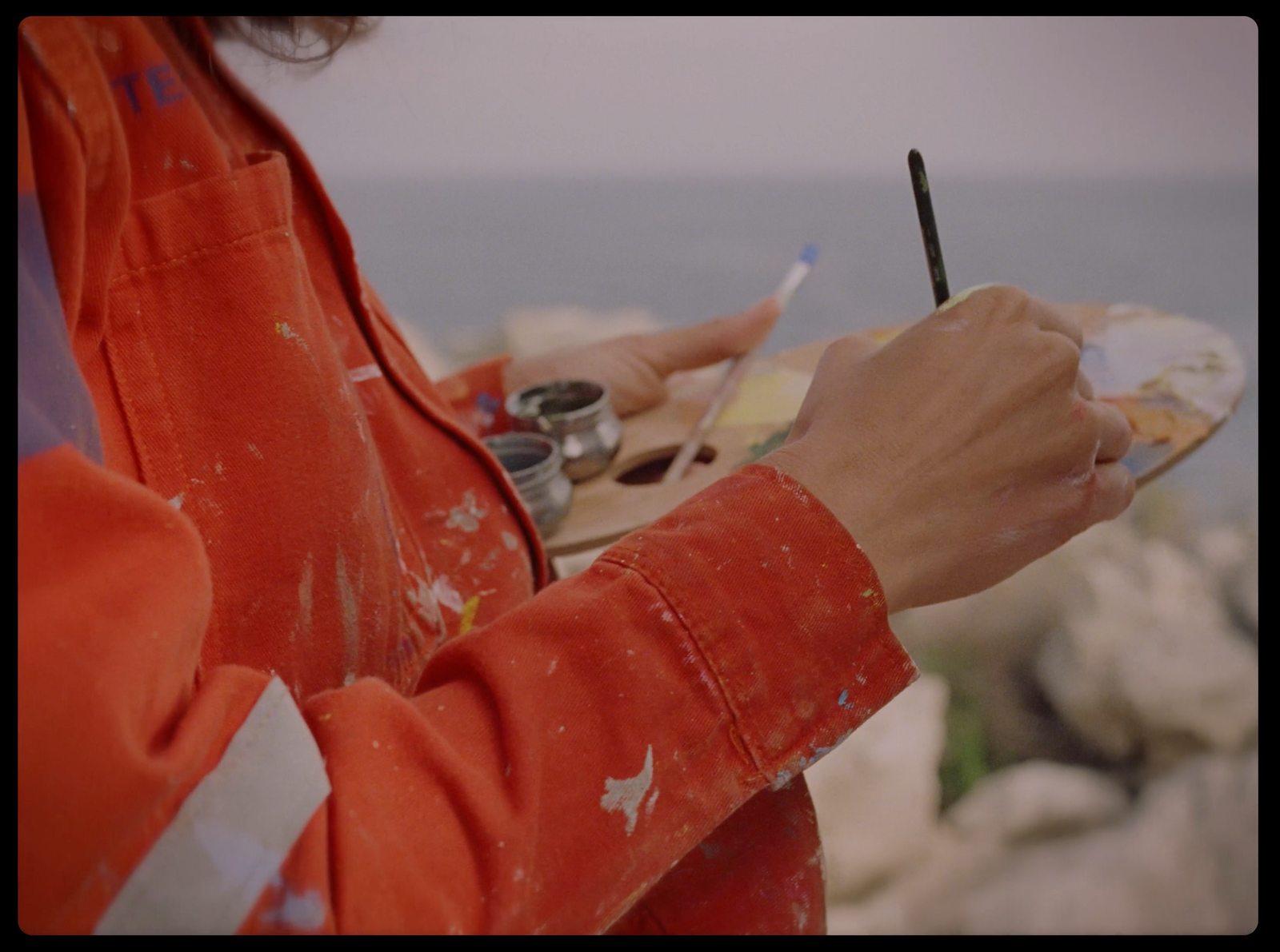 a person holding a paintbrush and a paint palette