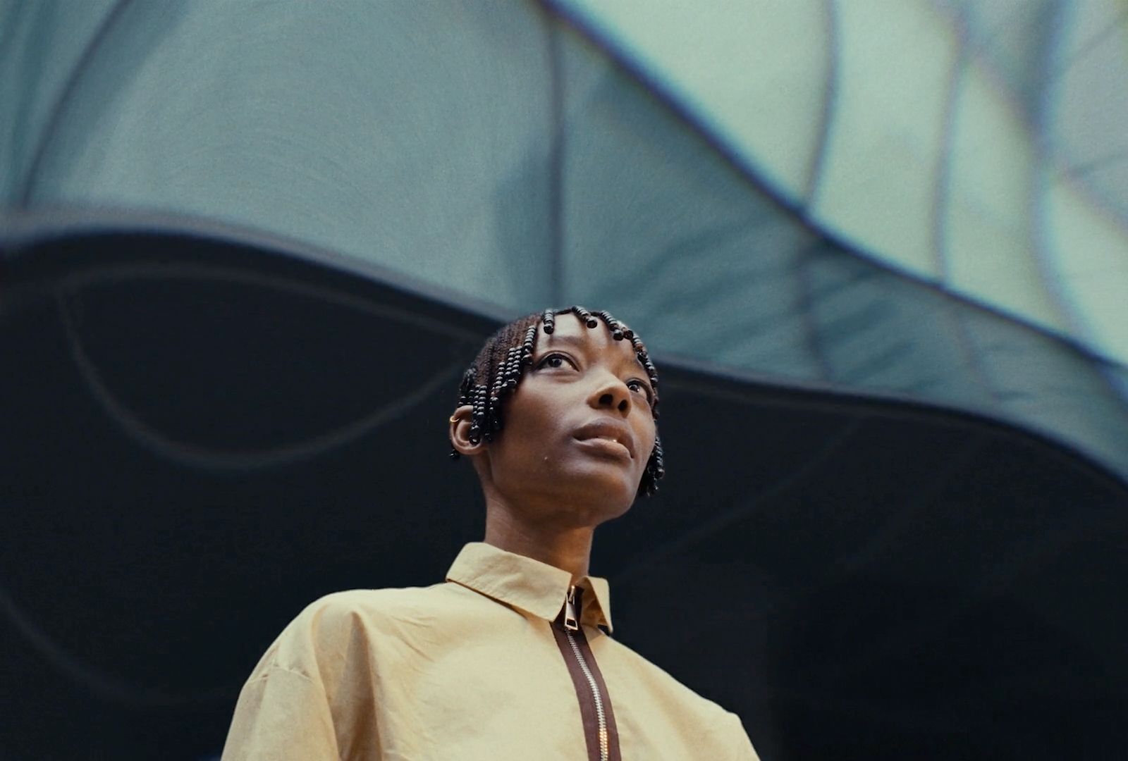 a woman wearing a yellow shirt and a brown tie