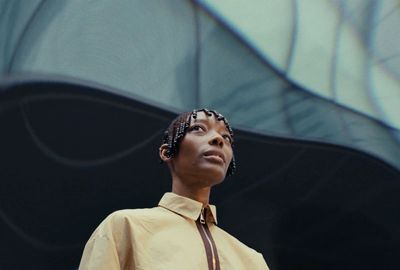 a woman wearing a yellow shirt and a brown tie