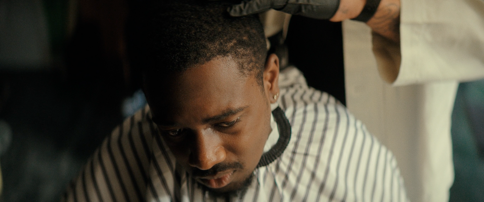 a man getting his hair cut at a barber shop