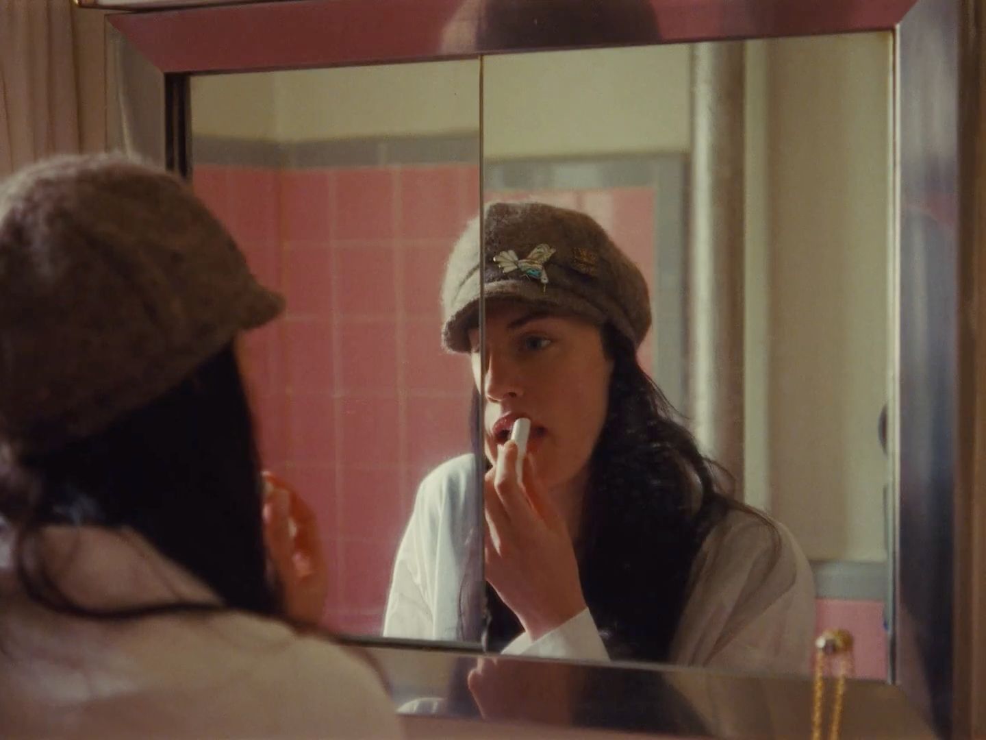 a woman brushing her teeth in front of a mirror