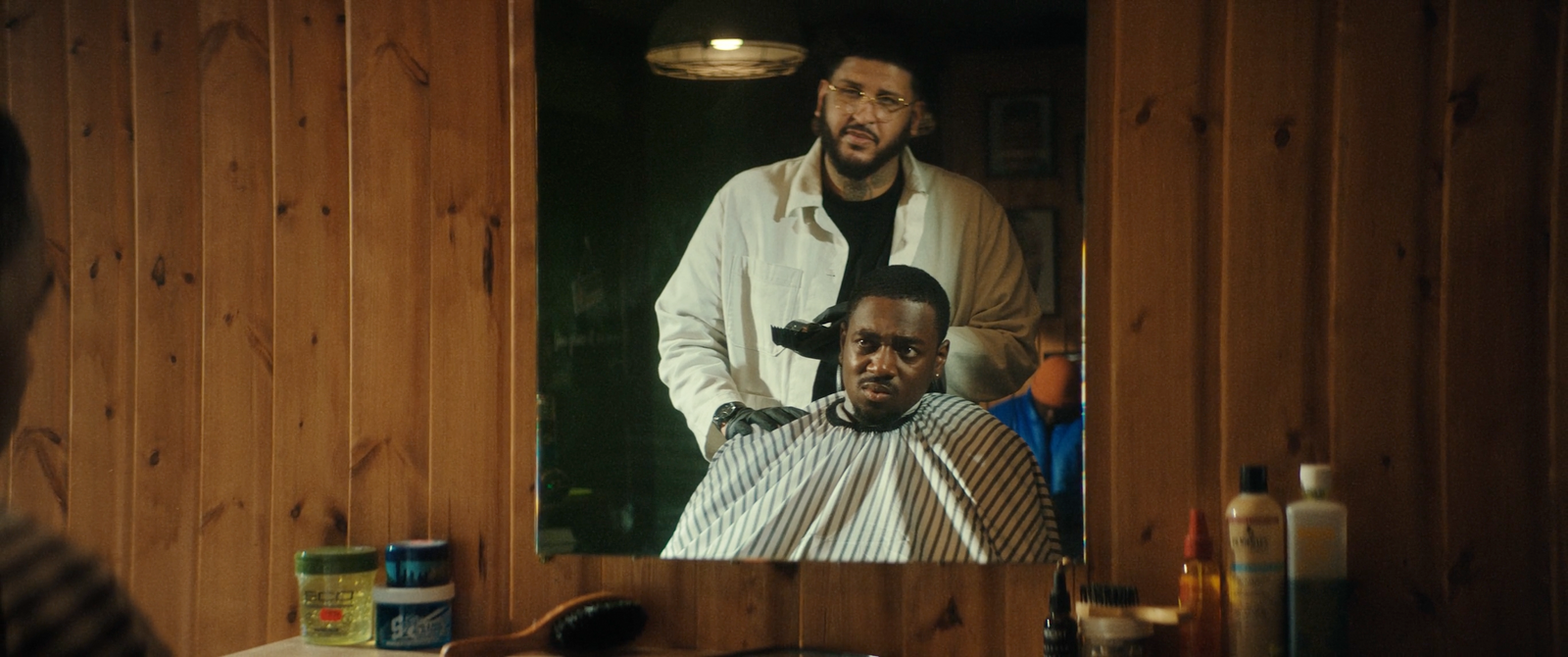 a man getting his hair cut in front of a mirror