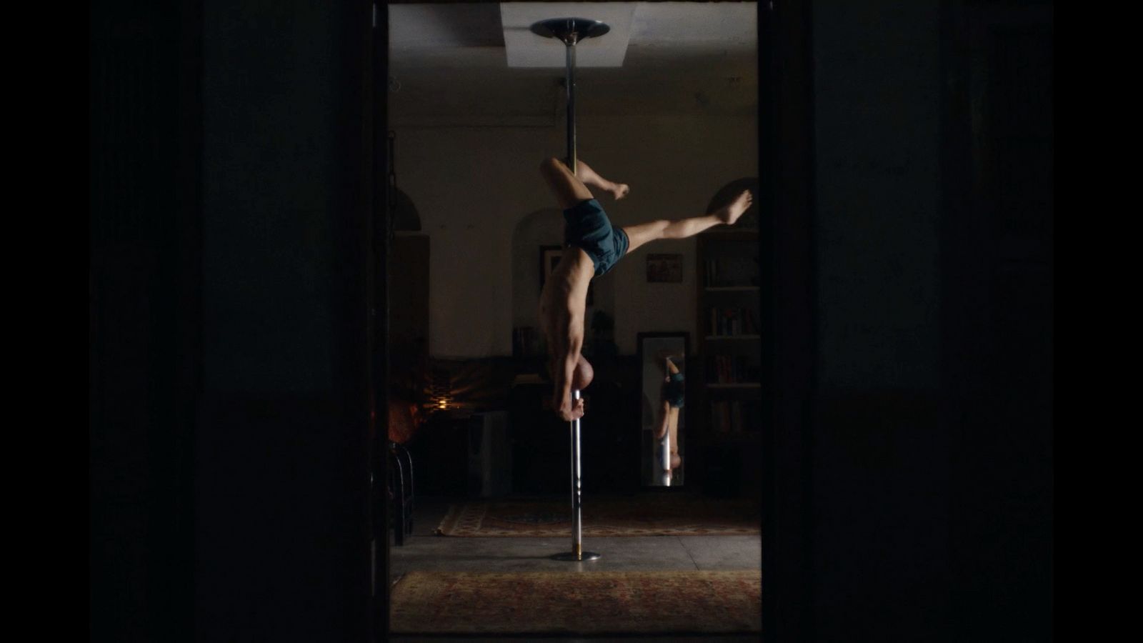 a man is doing a handstand on a pole