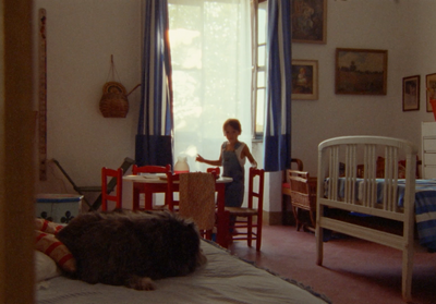 a little boy standing in a bedroom next to a baby crib