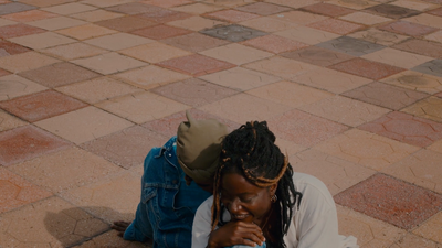 a woman sitting on the ground looking at her cell phone