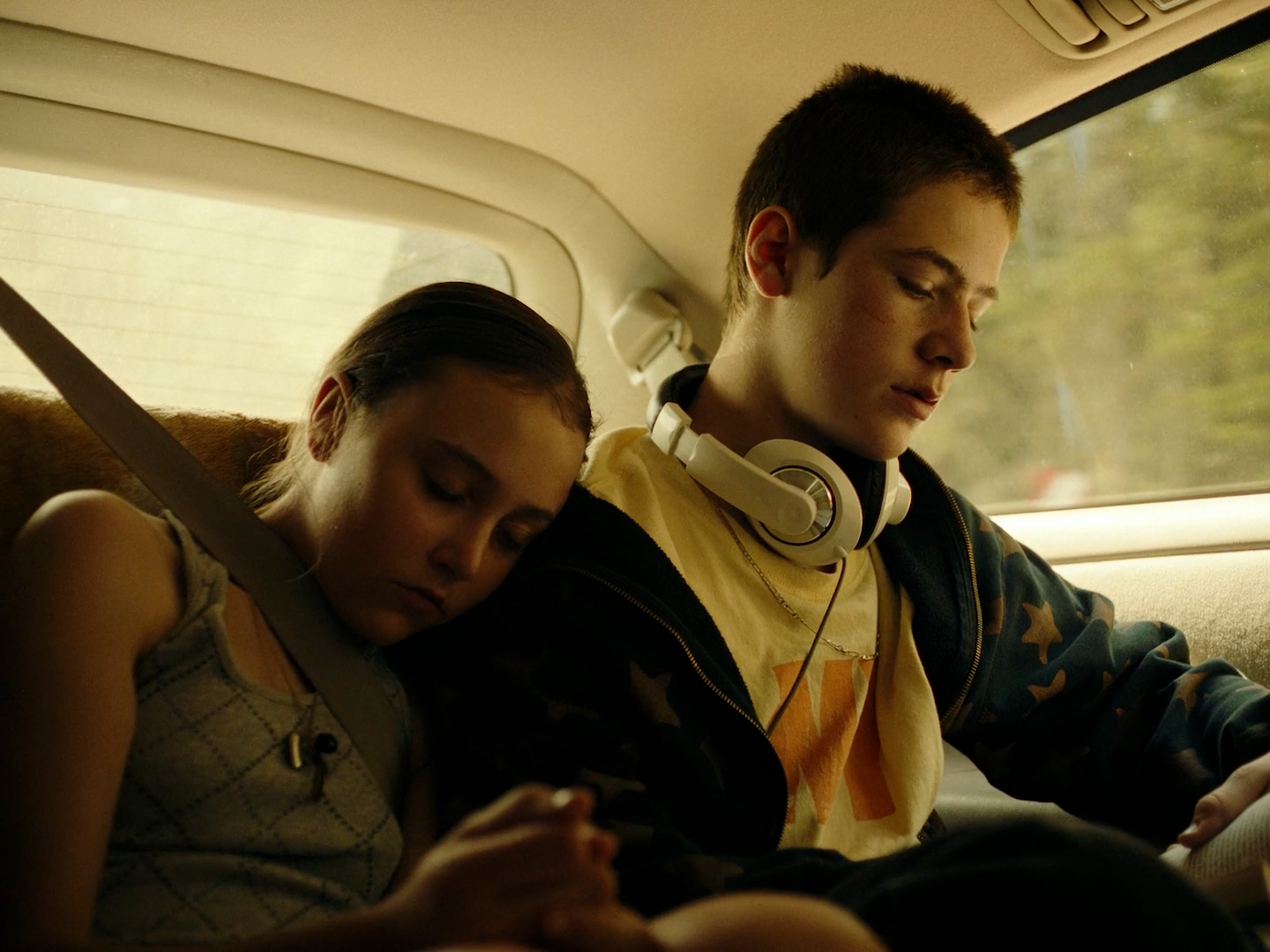 a man and a woman sitting in the back of a car