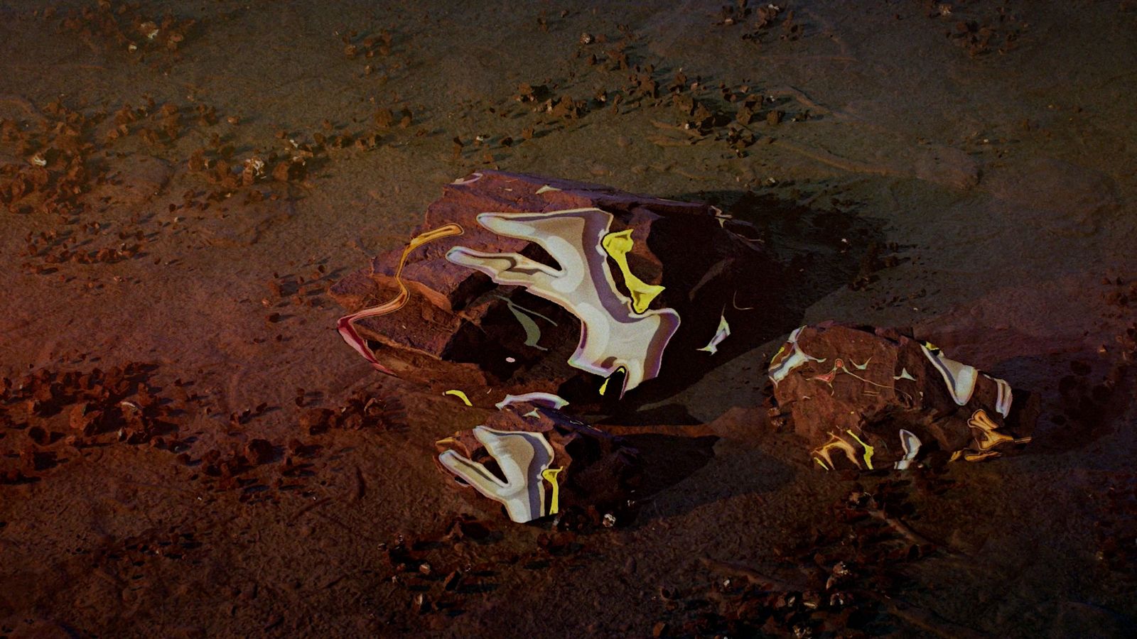 a pair of shoes sitting on top of a dirt field