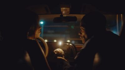 a man and a woman sitting in a car at night