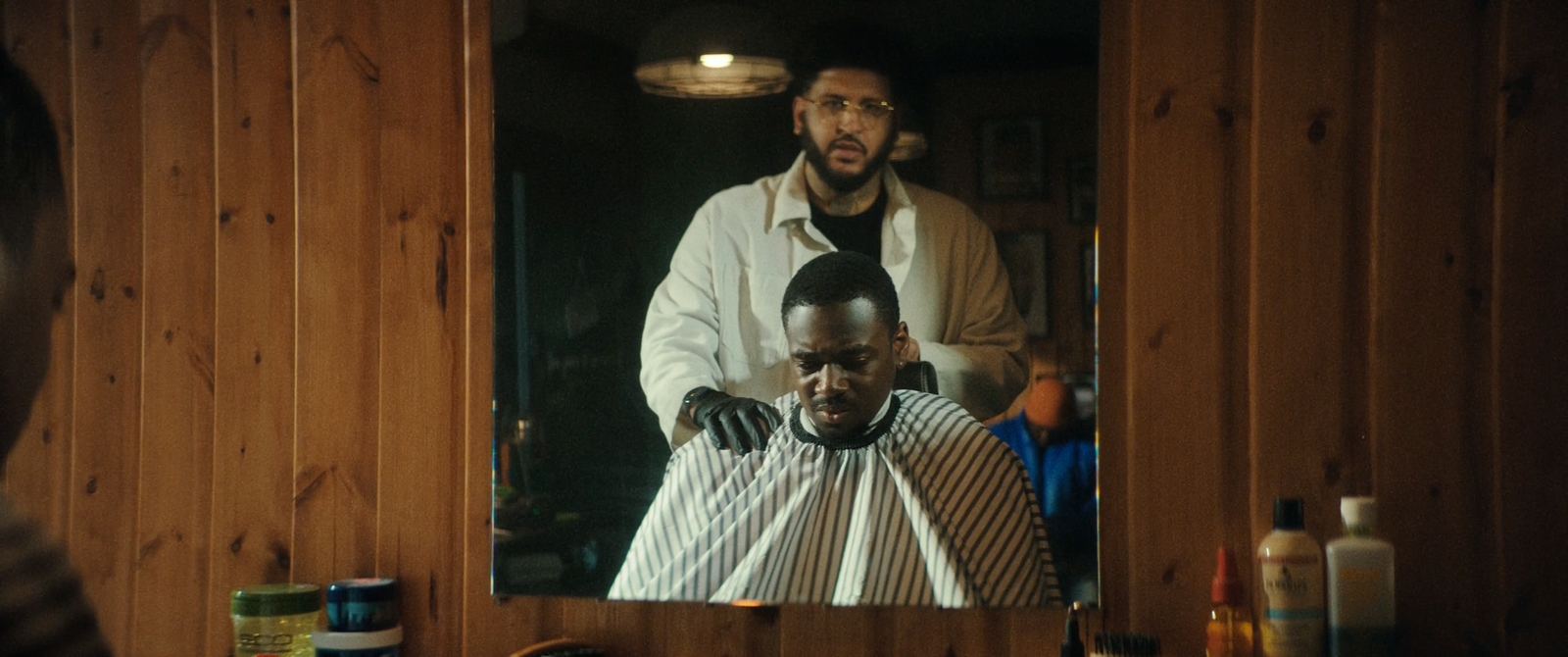 a man getting his hair cut in front of a mirror