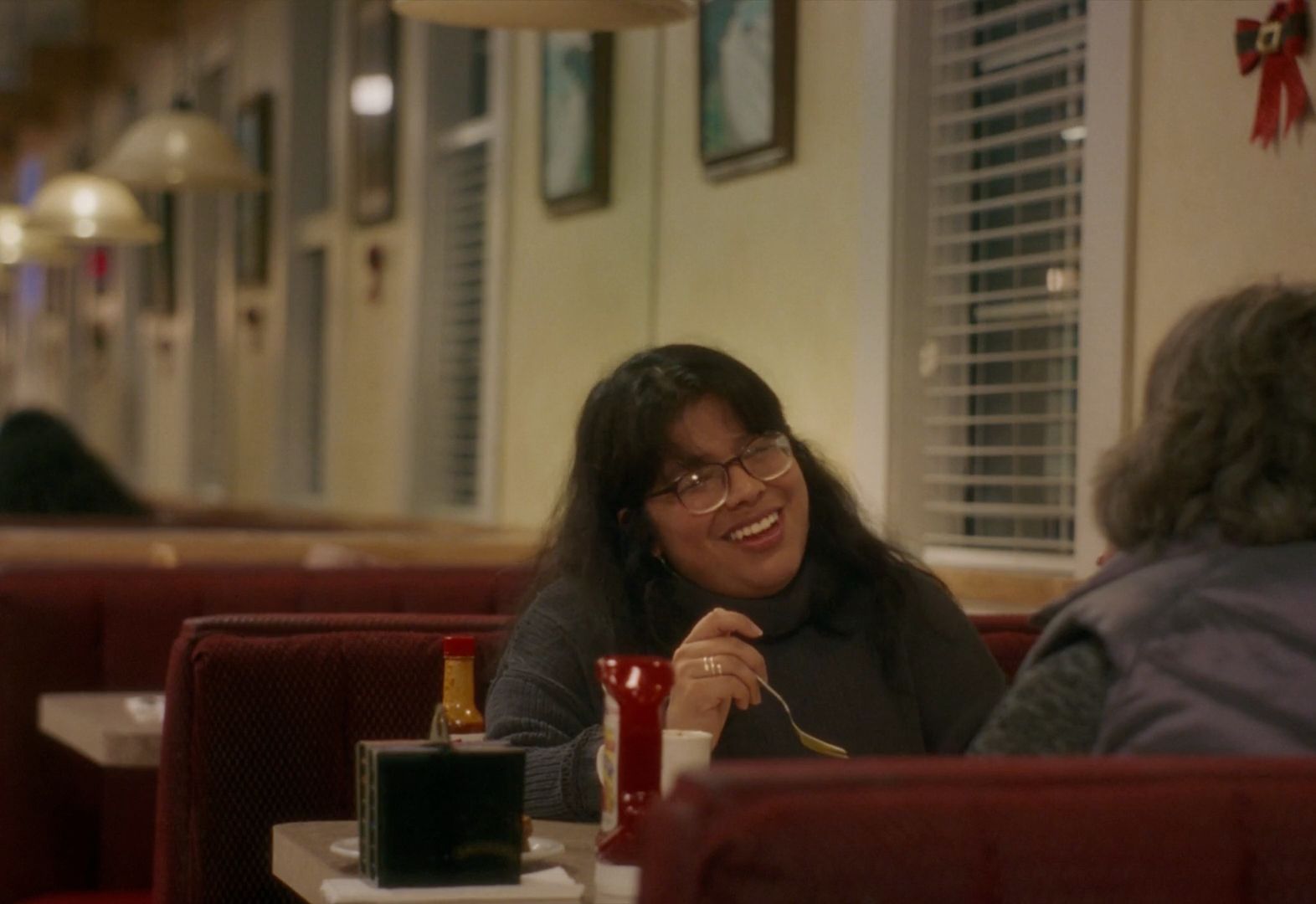 a woman sitting at a table in a restaurant