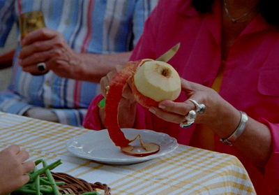 a woman holding an apple on top of a plate