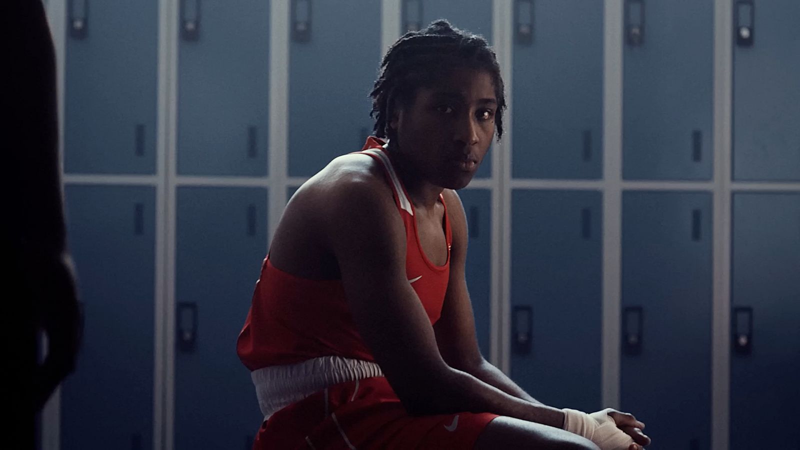 a man in a locker room with lockers in the background