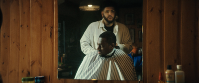 a man getting his hair cut in front of a mirror