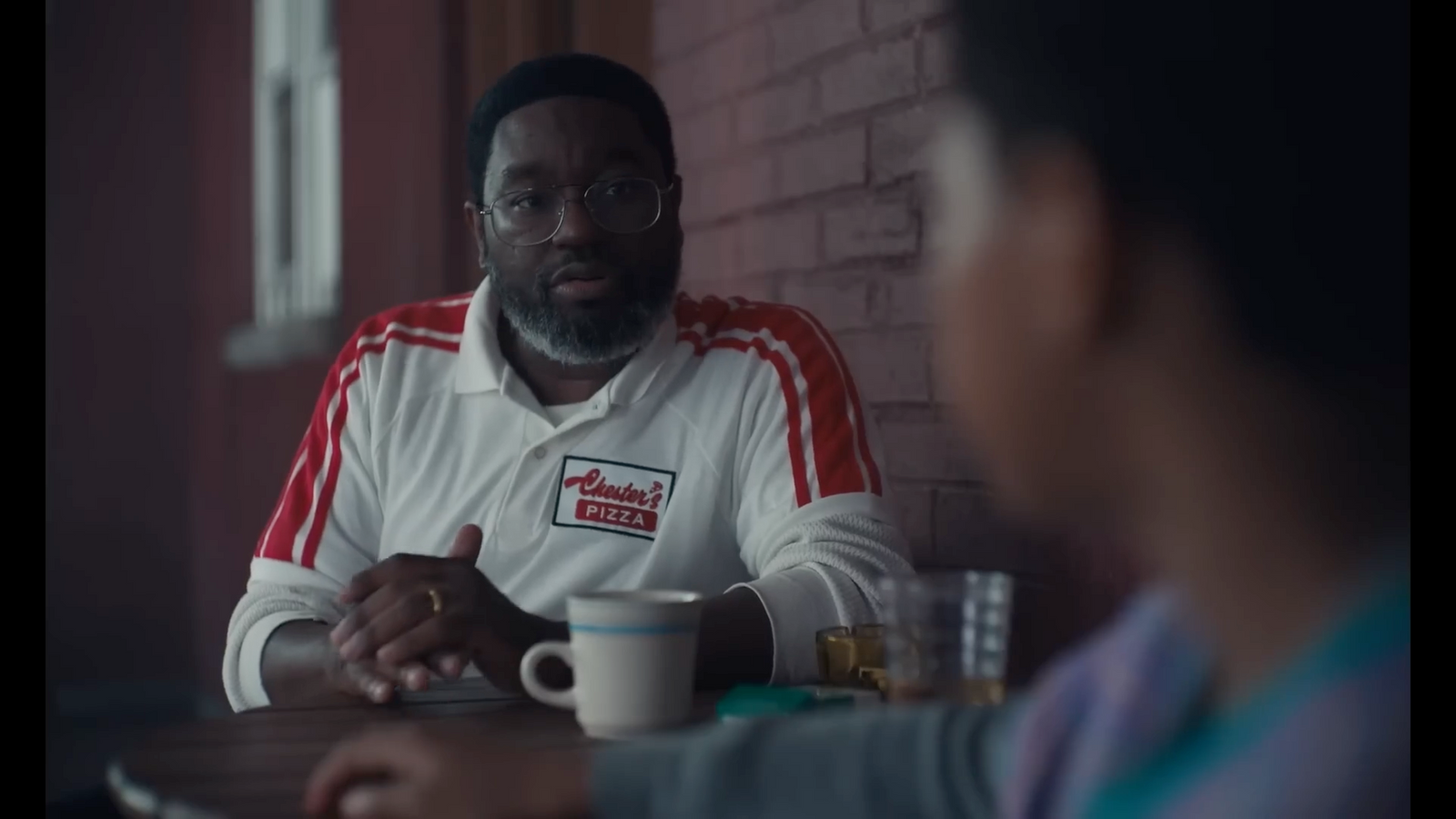 a man sitting at a table with a cup of coffee