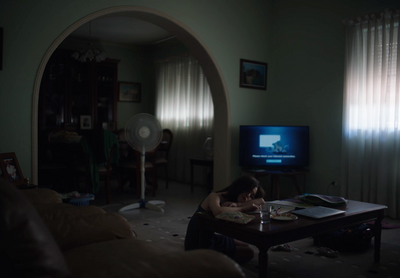 a woman sitting at a table in front of a tv