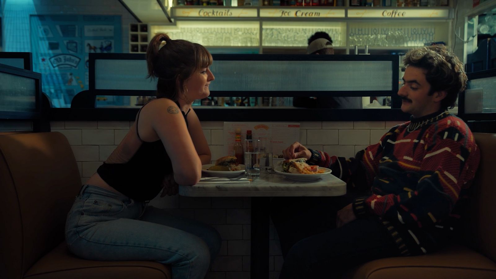 a man and a woman sitting at a table in a restaurant