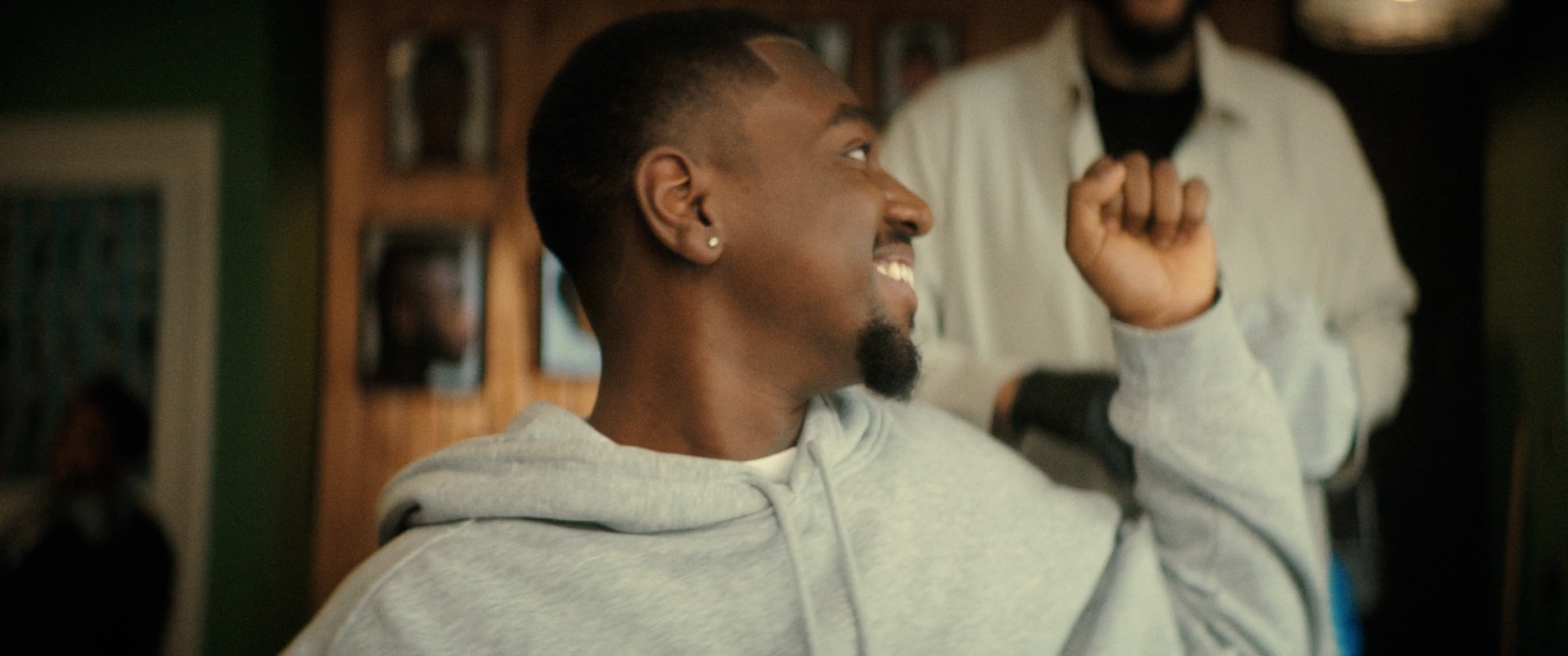 a man in a grey hoodie brushing his teeth