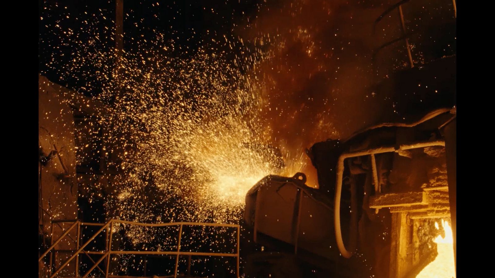 a large piece of metal being poured into a furnace